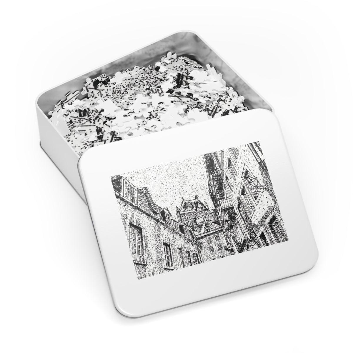 An open rectangular metal jigsaw puzzle box showing white puzzle pieces inside, with the lid displaying a black-and-white architectural illustration on a clean white background.