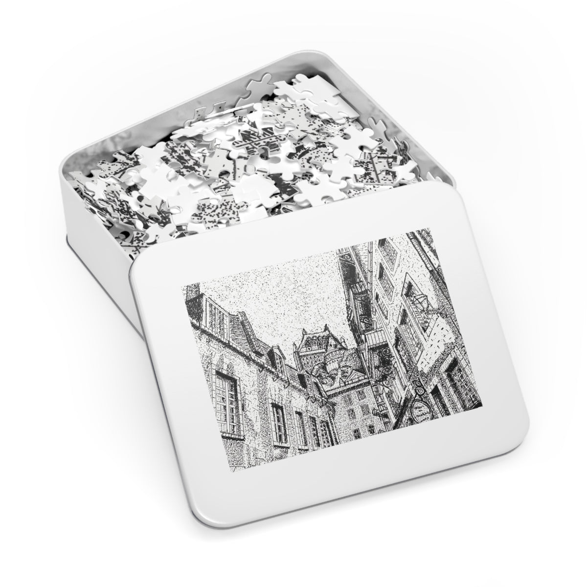 An open rectangular metal jigsaw puzzle box showing white puzzle pieces inside, with the lid displaying a black-and-white architectural illustration on a clean white background.